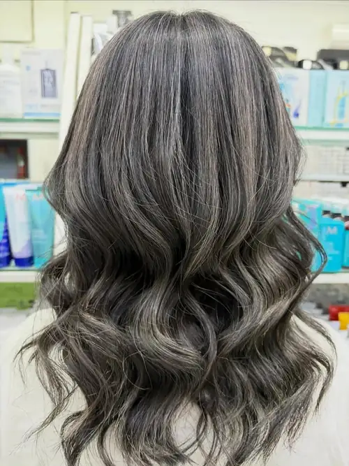 Shoulder-length soft brunette with lighter pieces, in loose waves