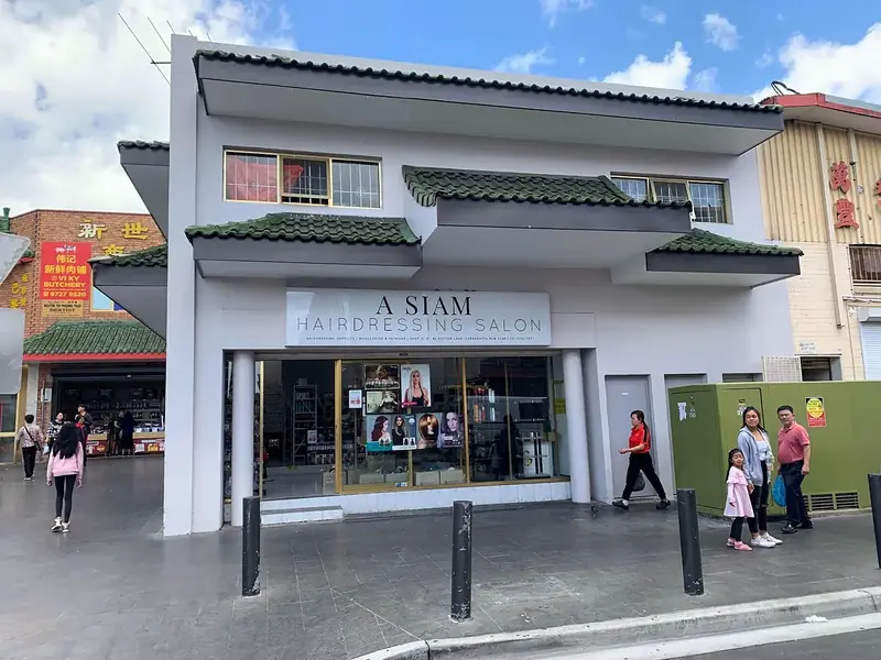 The A Siam Hairdressing Salon shopfront on Dutton Lane, a white sign under a green tiled roof